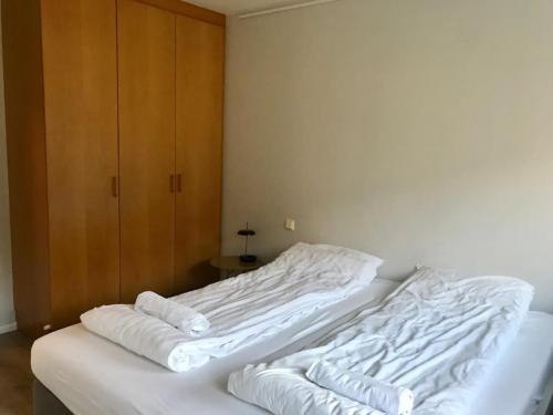劳加尔瓦特恩Laugarvatn Apartment的一间卧室配有两张带白色床单的床和橱柜
