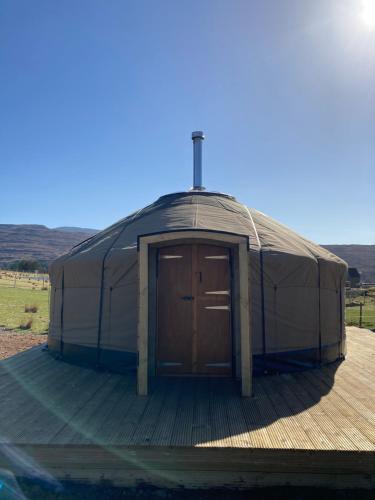 希尔代格Beinn Shieldaig Yurt的木制甲板上的圆顶帐篷,配有木门