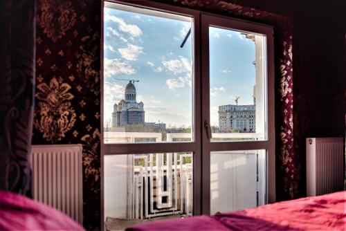 布加勒斯特Parliament Marriott Unirii Square 5 Bedrooms Luxury Apartment Old Town的卧室窗户,享有城市美景