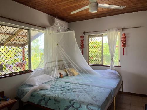 维拉港TRADEWINDS VILLAS的一间卧室配有一张带蚊帐的床