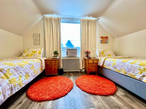 西雅图Private Room with 2 Twin Beds- Air Conditioning and Shared Bathrooms的一间卧室配有两张床和两张红色地毯。