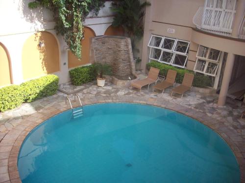 乌贝拉巴塔马雷拉斯公园酒店的一座带椅子的庭院内的游泳池以及一座建筑