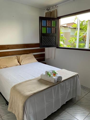 佩德拉斯港Chalés do Porto的一间卧室配有一张带白色床单的床和一扇窗户。