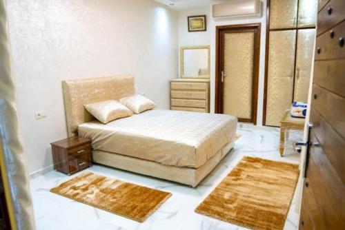 阿加迪尔Riad dar salam的一间卧室配有一张带两块地毯和镜子的床