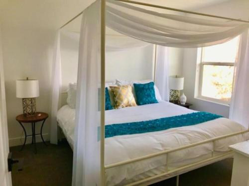 德雷珀Draper Luxury Townhouse的一间卧室配有一张带蓝色枕头的天蓬床