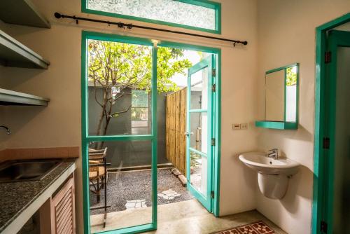 奥南海滩Nomads Ao Nang的浴室设有绿门和水槽