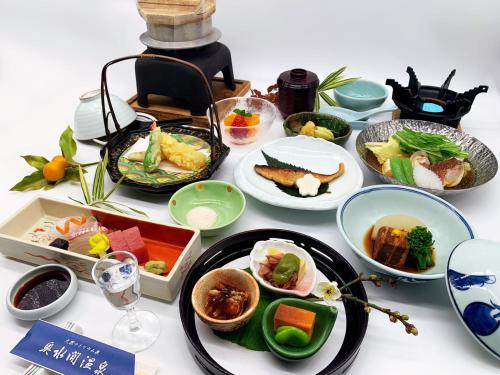 贝冢市奥水間温泉酒店的餐桌上摆放着食物和盘子