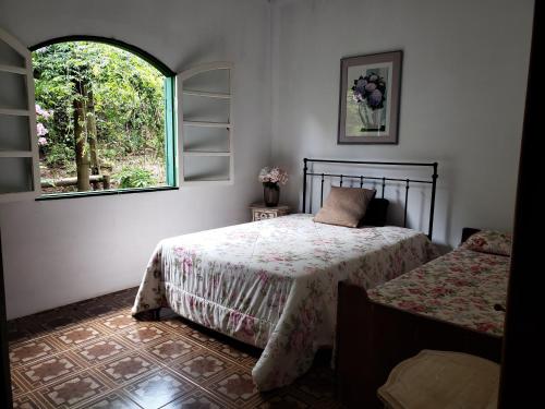 德尔芬莫雷拉Sitio Natividade的一间卧室设有两张床和窗户。