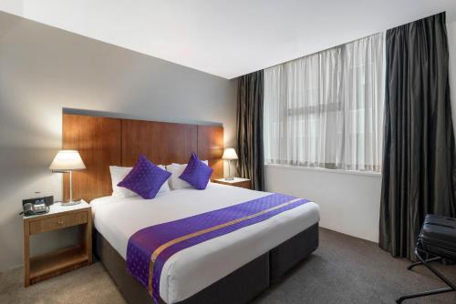 墨尔本里吉斯公园格里芬套房的酒店客房配有一张带蓝色枕头的大床