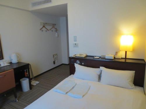 熊本熊本内斯特酒店的酒店客房,配有带两条毛巾的床