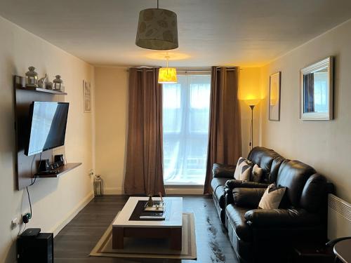 哈洛Radiant2 bedroom apartment in the heart of Harlow town的客厅配有真皮沙发和茶几