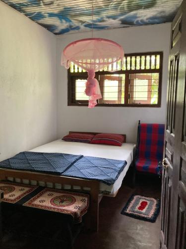 乌纳瓦图纳Hostel Singha Lounge的一间带一张床和吊灯的小卧室