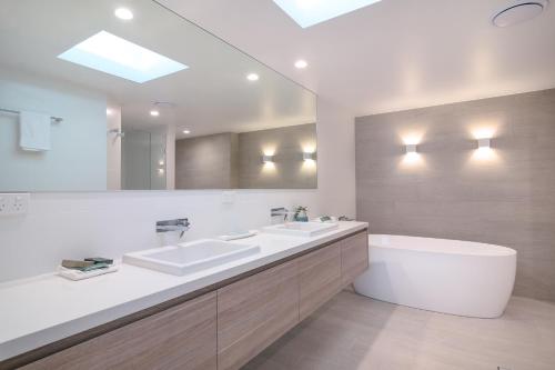 道格拉斯港曼德勒豪华海滨公寓酒店的浴室配有两个盥洗盆和浴缸。