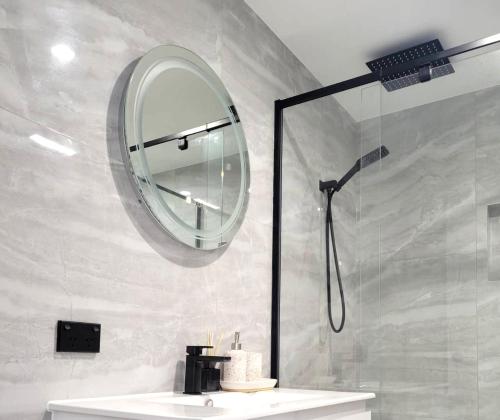 玛志洛Beachside One Bedroom Flat Retreat的设有带镜子和水槽的淋浴的浴室