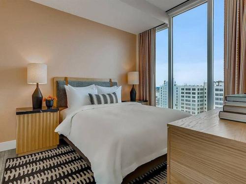 洛杉矶Top Floor High Rise 3 Bed DTLA Skyscraper Penthouse的一间卧室设有一张大床和一个大窗户