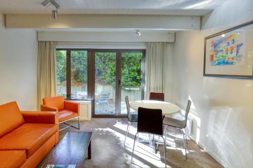 皇后镇景苑套房&公寓酒店的客厅配有沙发和桌椅