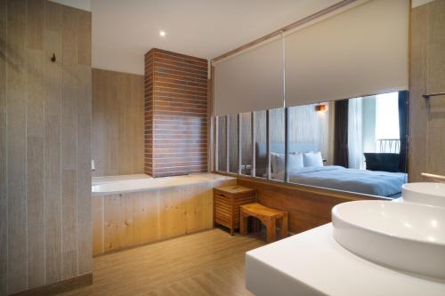 长滨乡畫日風尚會館Sinasera Resort的带浴缸、水槽和床的浴室