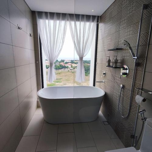 绥和市Beach apartment apec Phú Yên的带浴缸的浴室和窗户