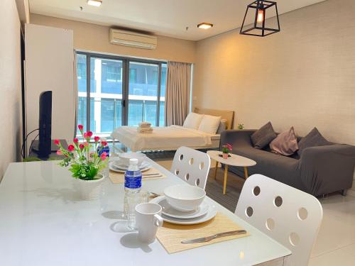 吉隆坡Mercu Summer Suite KLCC by Minshuku的客厅配有桌子和沙发