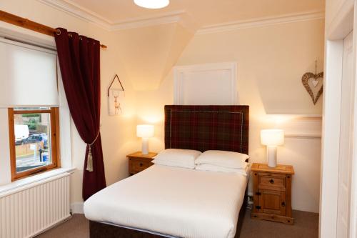 因弗内斯阿尔班和修道院大厦酒店的一间卧室配有一张带2个床头柜和2盏灯的床。