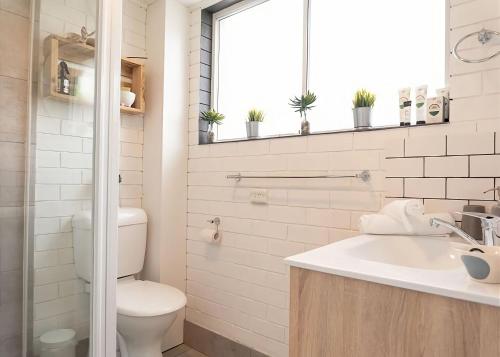 萨维特尔Lemongrass的一间带卫生间、水槽和窗户的浴室
