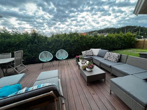 哥德堡Modern stor villa nära havet och 10 min till city的木制甲板上配有沙发和椅子的庭院
