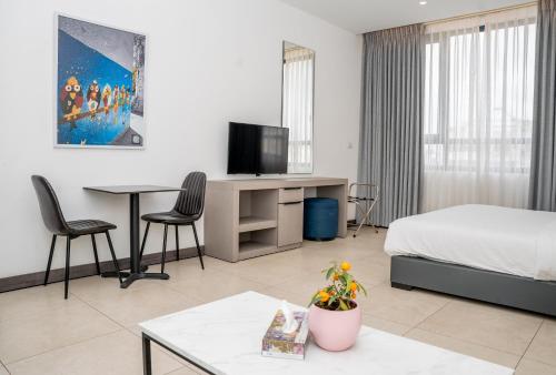 安曼Liv Weibdeh Hotel Suites的酒店客房,配有床和电视