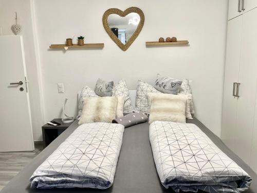 洛索内Residenza Tulipani的一间卧室配有两张床和心形镜子