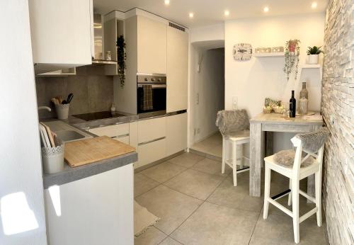 洛索内Residenza Tulipani的厨房配有白色橱柜和桌椅