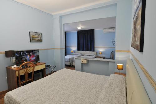 圣雷莫索勒马雷酒店的酒店客房带一张床铺、一张书桌和一间卧室