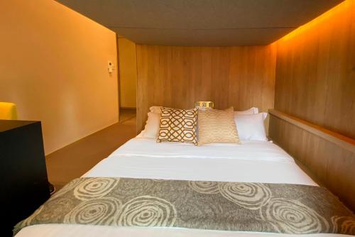 新加坡ST Signature Tanjong Pagar, DAYUSE, 8 hours, 10AM-6PM的一间卧室配有一张大床和枕头