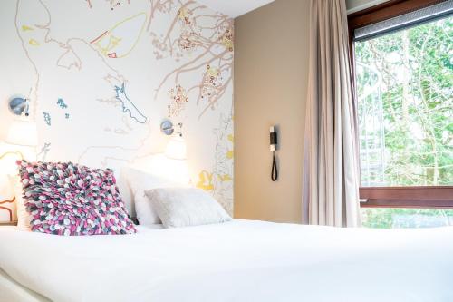 卑尔根blooming的卧室配有白色的床和窗户。