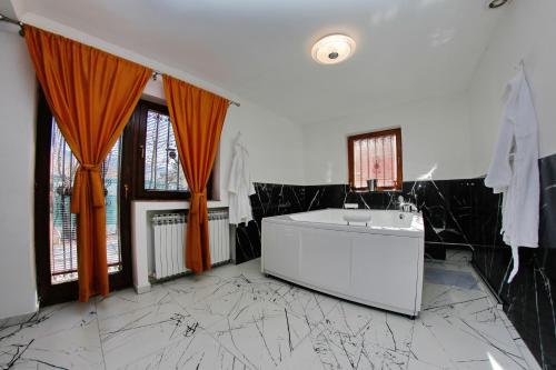 萨拉热窝Hedonist Spa Apartment的一间带浴缸和水槽的浴室
