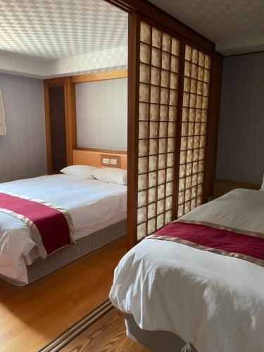 高雄梅花大饭店的一间卧室设有两张床和窗户。