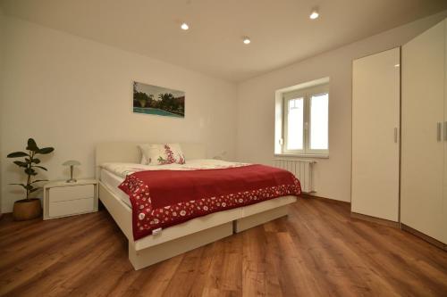 马里博尔SEDAMI的一间卧室配有一张带红色毯子的床