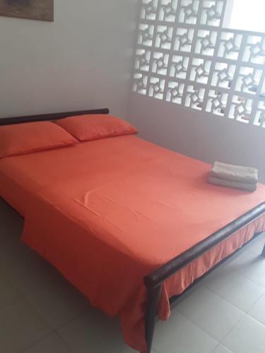卡塔赫纳Apartamento entero con vista al mar的床上有橙色的被子