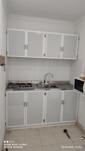 卡塔赫纳Apartamento entero con vista al mar的厨房配有白色橱柜和水槽