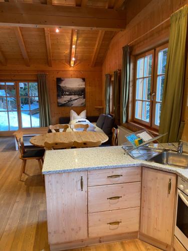 上陶恩MOUNTAINRANGER - Lodge的小屋内的厨房和带桌子的客厅