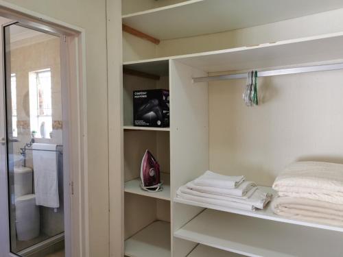约翰内斯堡Exclusive Private Room in Joburg No loadshedding的浴室设有衣柜和架子上的毛巾