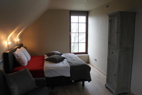 蒂尔特De Landweg的一间卧室设有一张床和一个窗口