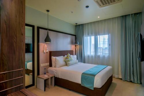 达累斯萨拉姆Aura Suites的一间卧室设有一张大床和一个窗户。
