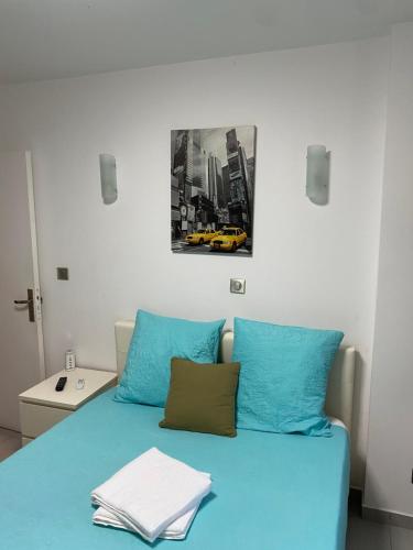 维勒班Résidence Zola 2的卧室配有一张蓝色的床,墙上挂着一幅画