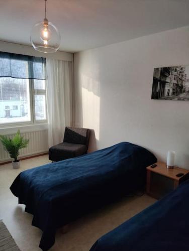 黑诺拉Toimiva kodikas yksiö的一间卧室配有蓝色的床和椅子