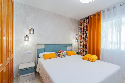 卡拉德费斯特拉特Espanatour BENIMAR的一间卧室配有两张带黄色枕头的床