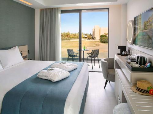 拉纳卡Mercure Larnaca Beach Resort的酒店客房,配有带两条毛巾的床