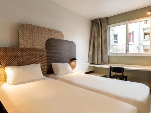 马赛B&B HOTEL Marseille Prado Parc des Expositions的酒店客房设有两张床和窗户。