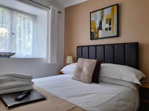 圣艾夫斯瑟乐斯通旅馆的一间卧室配有一张白色大床和黑色床头板