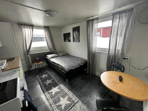 基律纳Apartment with shared bathroom in central Kiruna 1的一个小客厅,配有一张床和一张桌子