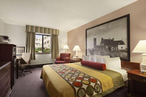 密尔沃基密尔沃基机场速8酒店的酒店客房,配有一张床、一张桌子和椅子