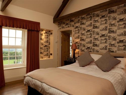 科布里奇Duke of Wellington Inn的一间卧室设有一张大床和一个窗户。